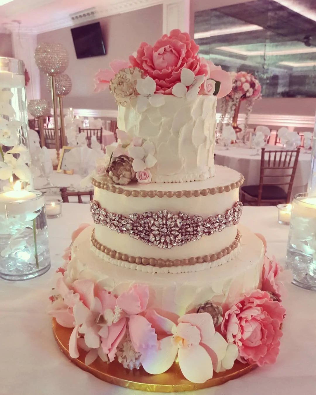 Dark-base tiered cake decorated with fresh flowers
